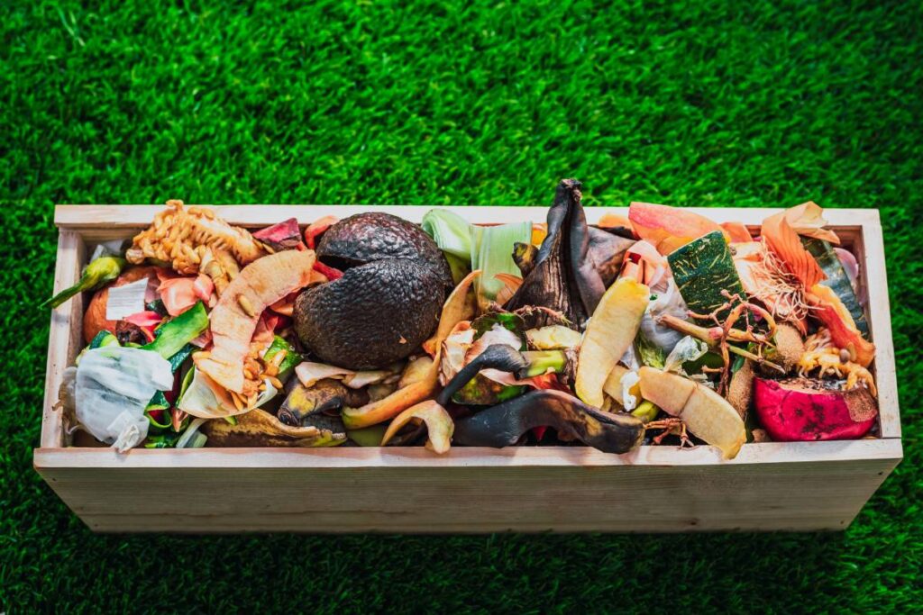 Peelings and organic waste in a wooden crate to create homemade compost.